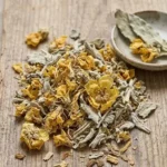 Corolles séchées de fleurs de Bouillon blanc (Verbascum thapsus) sur un support en bois, montrant la partie de la plante utilisée pour apaiser la toux sèche.